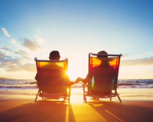couple holding hands sitting on beach couple holding hands sitting on beach