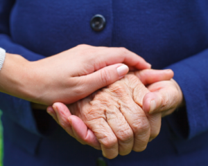 woman and elderly woman holding hands woman and elderly woman holding hands