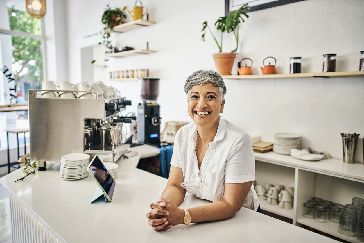 cafe portrait of woman or small business owner with startup success, restaurant goals and barista services. boss, manager or indian senior employer in coffee shop for leadership and a welcome smile