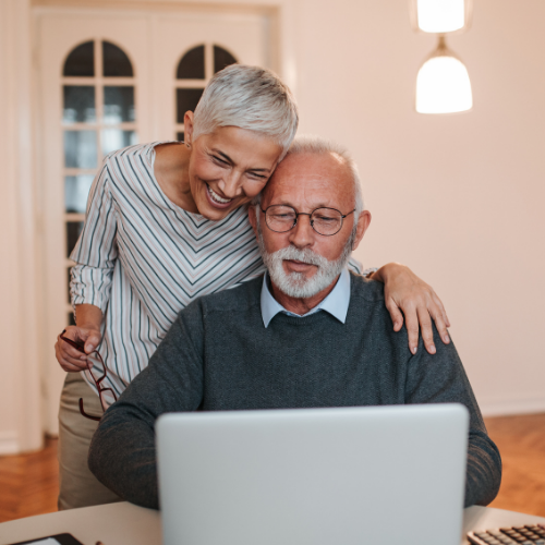 Elderly couple having discussion look at laptop