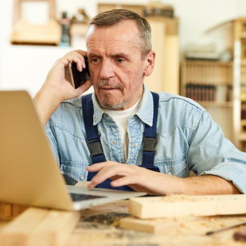 Man working at computer , talking on the phone