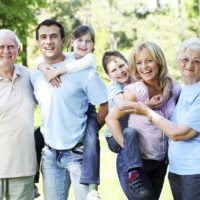 Portrait of a extended happy family standing in the park.